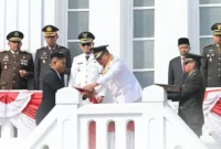 Wali Kota Bukittinggi Ramlan Nurmatias menyerahkan duplikat Bendera Pusaka di bawah Jam Gadang, Senin (17/8/2026). (Foto: Diskominfo Bukittinggi)