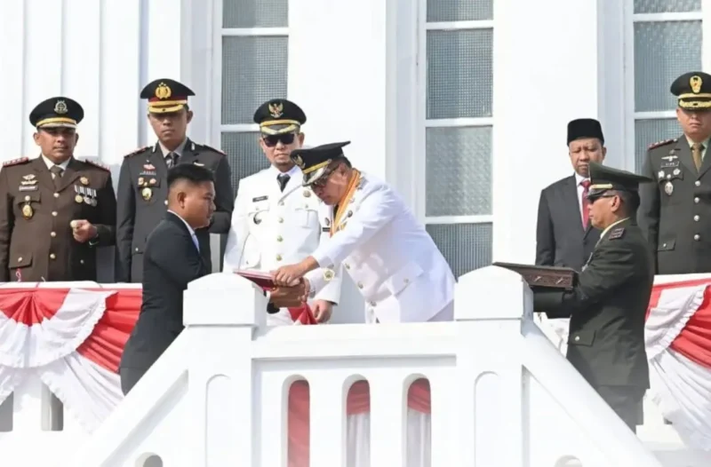 Wali Kota Bukittinggi Ramlan Nurmatias menyerahkan duplikat Bendera Pusaka di bawah Jam Gadang, Senin (17/8/2026). (Foto: Diskominfo Bukittinggi)