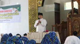 Camat Lubuk Begalung Ikrar Prakarsa menyampaikan sambutan saat menghadiri Khatam Al-Qur’an yang digelar Majelis Taklim di Masjid Al-Muttaqin, Kelurahan Pagambiran Ampalu Nan XX, Sabtu (22/8/2026). (Foto: Pemko Padang)