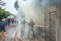 Petugas Dinas Damkar Padang memadamkan kobaran api yang menghanguskan satu unit rumah dan toko PMD di Jalan Asra I No. 22, Dadok Tunggul Hitam, Padang, Senin (3/8/2026). (Foto: Dok. Dinas Damkar Padang)