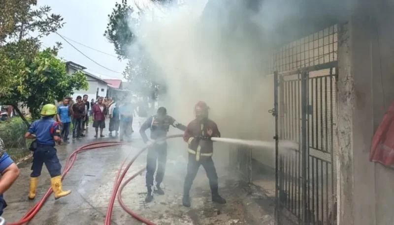 Petugas Dinas Damkar Padang memadamkan kobaran api yang menghanguskan satu unit rumah dan toko PMD di Jalan Asra I No. 22, Dadok Tunggul Hitam, Padang, Senin (3/8/2026). (Foto: Dok. Dinas Damkar Padang)
