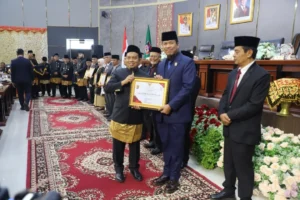 Ketua DPRD Padang Muharlion menyerahkan penghargaan Pin Emas