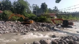 Dua alat berat terlihat bekerja melakukan normalisasi sungai yang terdampak hujan lebat di Kecamatan Lubuk Kilangan. (Foto: Ist)