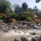Dua alat berat terlihat bekerja melakukan normalisasi sungai yang terdampak hujan lebat di Kecamatan Lubuk Kilangan. (Foto: Ist)