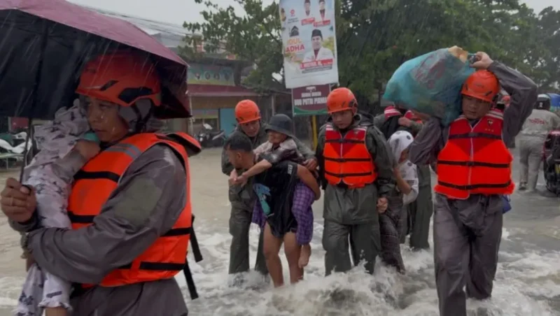 Personel SAR Brimob Polda Sumbar mengevakuasi warga terjebak banjir. (Foto: Polda Sumbar)