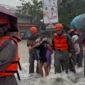 Personel SAR Brimob Polda Sumbar mengevakuasi warga terjebak banjir. (Foto: Polda Sumbar)