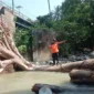 Pohon berukuran besar tersangkut di bawah jembatan SMAN 14 Padang dan menghambat akses aliran Sungai Batang Aro di Kelurahan Batu Gadang, Kecamatan Lubuk Kilangan, Sabtu (22/8/2026). (Foto: BPBD Padang)