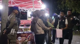 Petugas Satpol PP Padang memberikan surat teguran dan pemahaman secara persuasif kepada PKL yang berjualan di atas trotoar kawasan Batang Arau, Sabtu malam (22/8/2026). (Foto: Dok. Humas Satpol PP Padang)