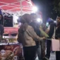 Petugas Satpol PP Padang memberikan surat teguran dan pemahaman secara persuasif kepada PKL yang berjualan di atas trotoar kawasan Batang Arau, Sabtu malam (22/8/2026). (Foto: Dok. Humas Satpol PP Padang)