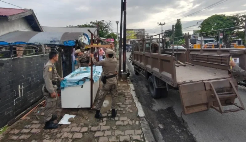 Personel Satpol PP Padang menertibkan lapak PKL yang berdiri di atas trotoar Pasar Alai, Senin (3/8/2026). (Foto: Satpol PP Padang)