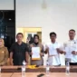 Kombes Pol. Teddy Fanani dan Bill Irzano menandatangani kesepakatan damai untuk mengakhiri perselisihan secara kekeluargaan. (Foto: Polda Sumbar)