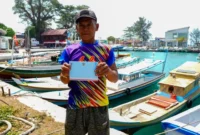 Salah seorang nelayan di Kepulauan Seribu memperlihatkan undangan dari Presiden Prabowo untuk menghadiri Upacara HUT ke-81 Kemerdekaan RI di Istana Merdeka pada 17 Agustus 2026. (Foto: BPMI Setpres)