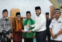 Wali Kota Padang Fadly Amran menyerahkan bantuan Al-Qur’an kepada Ketua Masjid Al Munawwarah Buya Masoed Abidin. (Foto: Pemko Padang)