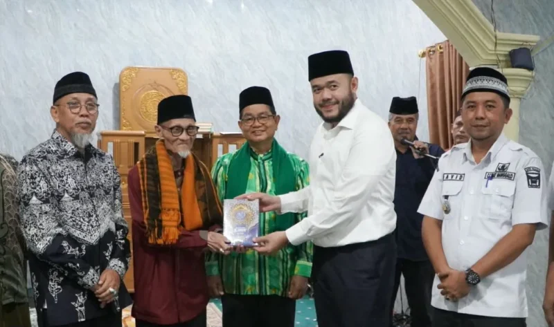 Wali Kota Padang Fadly Amran menyerahkan bantuan Al-Qur’an kepada Ketua Masjid Al Munawwarah Buya Masoed Abidin. (Foto: Pemko Padang)