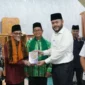 Wali Kota Padang Fadly Amran menyerahkan bantuan Al-Qur’an kepada Ketua Masjid Al Munawwarah Buya Masoed Abidin. (Foto: Pemko Padang)