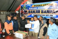 Kepala Dinas Sosial Padang Eri Sendjaya menyerahkan bantuan Pemko Padang kepada Bupati Solok Jon Firman Pandu di Posko Utama Arosuka, Kabupaten Solok, Kamis (24/9/2026). (Foto: Pemko Padang)