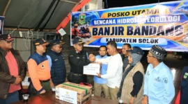 Kepala Dinas Sosial Padang Eri Sendjaya menyerahkan bantuan Pemko Padang kepada Bupati Solok Jon Firman Pandu di Posko Utama Arosuka, Kabupaten Solok, Kamis (24/9/2026). (Foto: Pemko Padang)