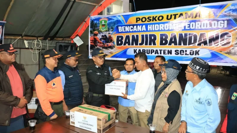 Kepala Dinas Sosial Padang Eri Sendjaya menyerahkan bantuan Pemko Padang kepada Bupati Solok Jon Firman Pandu di Posko Utama Arosuka, Kabupaten Solok, Kamis (24/9/2026). (Foto: Pemko Padang)