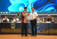 Gubernur Sumbar Mahyeldi Ansharullah memberikan penghargaan kepada perangkat daerah penerima Predikat A dalam rapat evaluasi kinerja di Aula Kantor Gubernur Sumbar, Minggu (27/9/2026). (Foto: Adpsb)