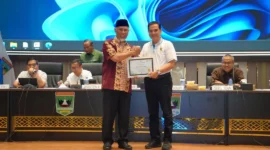 Gubernur Sumbar Mahyeldi Ansharullah memberikan penghargaan kepada perangkat daerah penerima Predikat A dalam rapat evaluasi kinerja di Aula Kantor Gubernur Sumbar, Minggu (27/9/2026). (Foto: Adpsb)