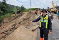 Kasat Lantas Polres Solok, Iptu Akbar Kharisma Tanjung menunjukkan kondisi Jalan Baru Kayu Aro yang tertutup material longsor, Kamis (24/9/2026). (Foto: Satlantas Polres Solok)