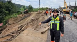 Kasat Lantas Polres Solok, Iptu Akbar Kharisma Tanjung menunjukkan kondisi Jalan Baru Kayu Aro yang tertutup material longsor, Kamis (24/9/2026). (Foto: Satlantas Polres Solok)