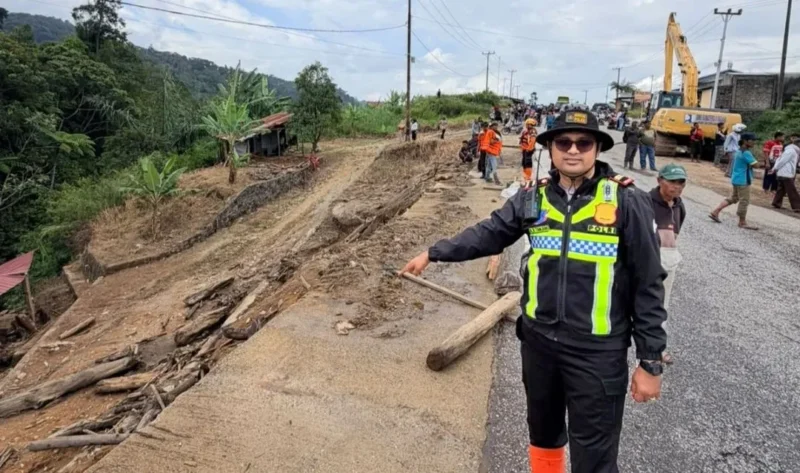 Kasat Lantas Polres Solok, Iptu Akbar Kharisma Tanjung menunjukkan kondisi Jalan Baru Kayu Aro yang tertutup material longsor, Kamis (24/9/2026). (Foto: Satlantas Polres Solok)