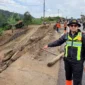 Kasat Lantas Polres Solok, Iptu Akbar Kharisma Tanjung menunjukkan kondisi Jalan Baru Kayu Aro yang tertutup material longsor, Kamis (24/9/2026). (Foto: Satlantas Polres Solok)