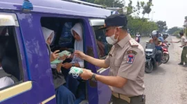 Kepala Pelaksana BPBD Padang, Hendri Zulviton membagikan masker kepada penumpang angkot. (Foto: BPBD Padang)