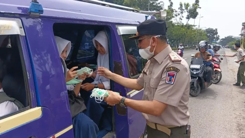 Kepala Pelaksana BPBD Padang, Hendri Zulviton membagikan masker kepada penumpang angkot. (Foto: BPBD Padang)