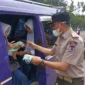 Kepala Pelaksana BPBD Padang, Hendri Zulviton membagikan masker kepada penumpang angkot. (Foto: BPBD Padang)
