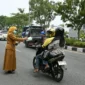 Asisten III Setdako Padang Corri Saidan bersama Kepala BPBD Padang Hendri Zulviton membagikan masker kepada pengendara. (Foto: Pemko Padang)