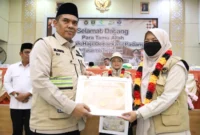 Kepala Kanwil Kemenhaj Sumbar, M. Rifki saat memberikan penghargaan kepada petugas haji
tahun 1447 Hijriah/2026 Masehi. (Foto: Kemenhaj Sumbar)