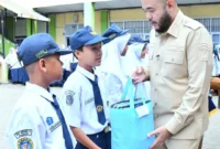 Wali Kota Padang Fadly Amran menyerahkan bantuan seragam sekolah gratis kepada siswa kurang mampu. (Foto: Pemko Padang)