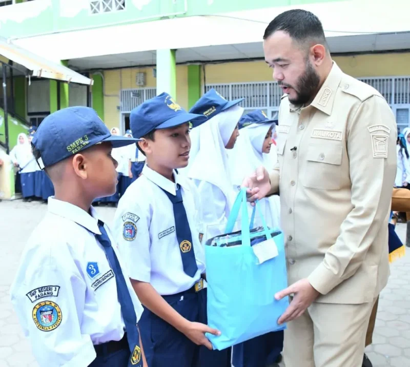 Wali Kota Padang Fadly Amran menyerahkan bantuan seragam sekolah gratis kepada siswa kurang mampu. (Foto: Pemko Padang)