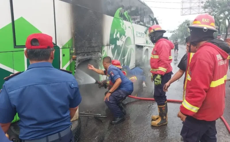Petugas Damkar Padang memadamkan api yang membakar ban bus EPA Star di Bandar Buat, Kota Padang, Selasa (13/10/2026). (Foto: Dinas Damkar Padang)