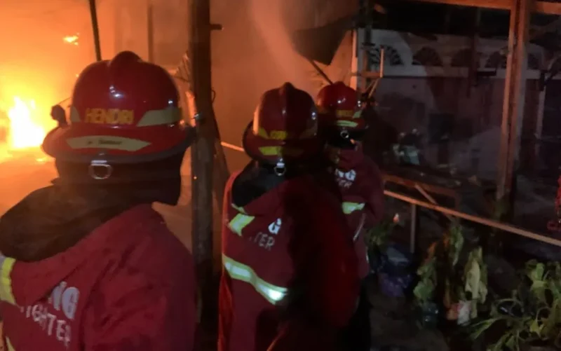 Petugas Damkar Padang berjibaku memadamkan api yang menghanguskan sebuah rumah dan depot air minum di Jalan Lolong Karan, RT 002 RW 002, Kelurahan Sungai Sapih, Kecamatan Kuranji, Kota Padang, Selasa malam (13/10/2026). (Foto: Dinas Damkar Padang)