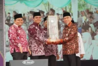 Wakil Wali Kota Padang Maigus Nasir menyerahkan tropi juara umum MTQ ke-42 tingkat Kota Padang 2026 kepada Camat Koto Tangah Rio Ebu Pratama. (Foto: Pemko Padang)