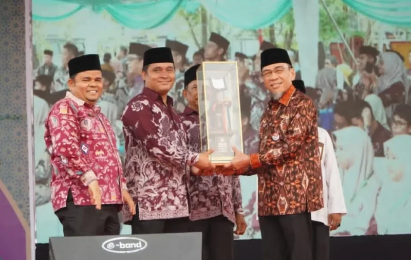 Wakil Wali Kota Padang Maigus Nasir menyerahkan tropi juara umum MTQ ke-42 tingkat Kota Padang 2026 kepada Camat Koto Tangah Rio Ebu Pratama. (Foto: Pemko Padang)