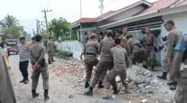 Petugas Satpol PP Padang membongkar pagar rumah warga yang memakan sebagian badan jalan di kawasan Dadok Tunggul Hitam, Jumat (2/10/2026). (Foto: Humas Satpol PP Padang)