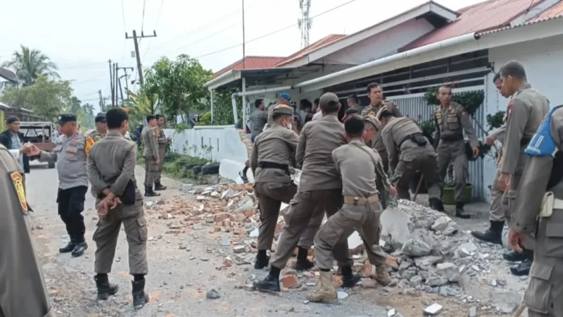 Petugas Satpol PP Padang membongkar pagar rumah warga yang memakan sebagian badan jalan di kawasan Dadok Tunggul Hitam, Jumat (2/10/2026). (Foto: Humas Satpol PP Padang)