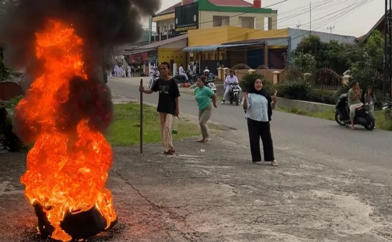 Warga sekitar memprotes pembakaran ban oleh pendemo di depan Rutan Padang, Senin (19/10/2026). (Foto: Ist)