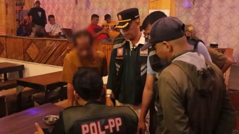 Personel Satpol PP Padang melakukan pembinaan kepada pemilik kafe karaoke yang memutar musik keras hingga larut malam, Minggu dini hari (4/10/2026). (Foto: Satpol PP Padang)