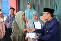 Wakil Wali Kota Padang, Maigus Nasir menyerahkan bantuan kepada warga pada Selasa (13/10/2026). (Foto: Pemko Padang)