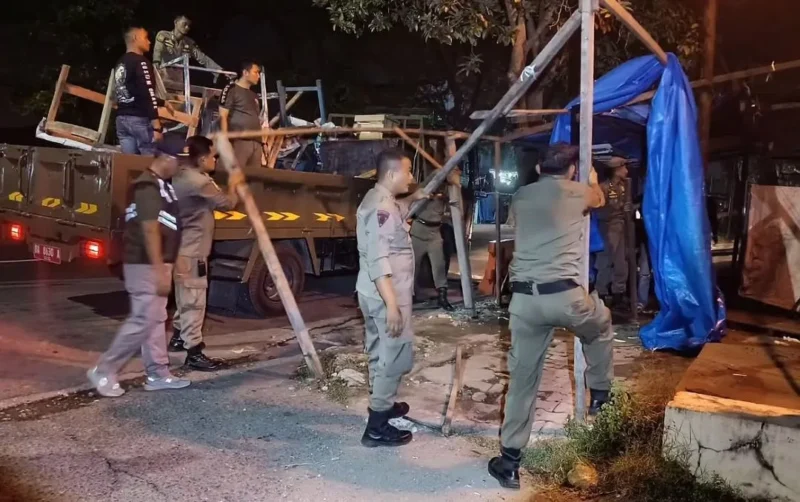 Petugas Satpol PP Padang membongkar lapak PKL yang berdiri di atas trotoar dan menutupi drainase di kawasan Jalan Sutan Syahrir, Kecamatan Padang Selatan, Jumat (9/10/2026) dini hari. (Foto: Humas Satpol PP Padang)